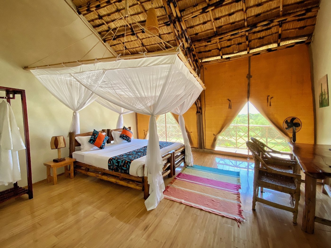 Netzumspanntes Bett in einem bambusgefassten Zimmer in der Bamboo Village Safari Lodge