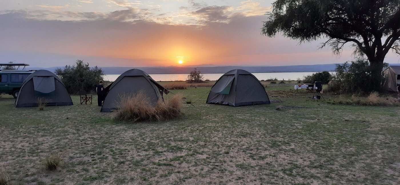 Tentes dôme plantées au-dessus de l'eau au coucher de soleil lors d'une sortie camping volant du Bwana Tembo Safari Camp