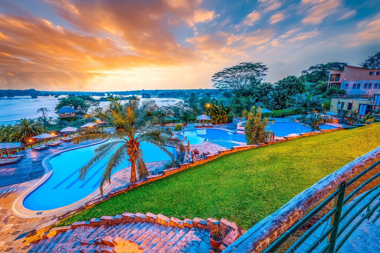 Zwembad en gazon van Chobe Safari Lodge boven de Nijl bij zonsondergang, Murchison Falls