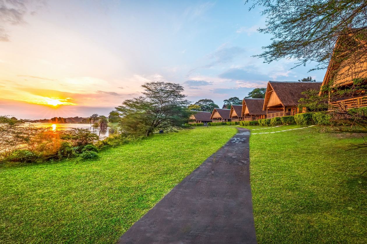 Chemin dans la pelouse menant aux chambres d'hôtes au coucher du soleil à Chobe Safari Lodge