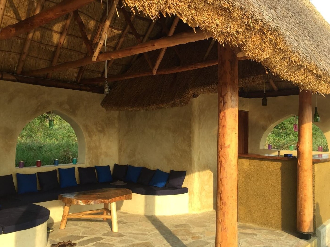 Lounge mit Strohdach, blauen Polsterbänken und Bogenfenstern in der Fort Murchison