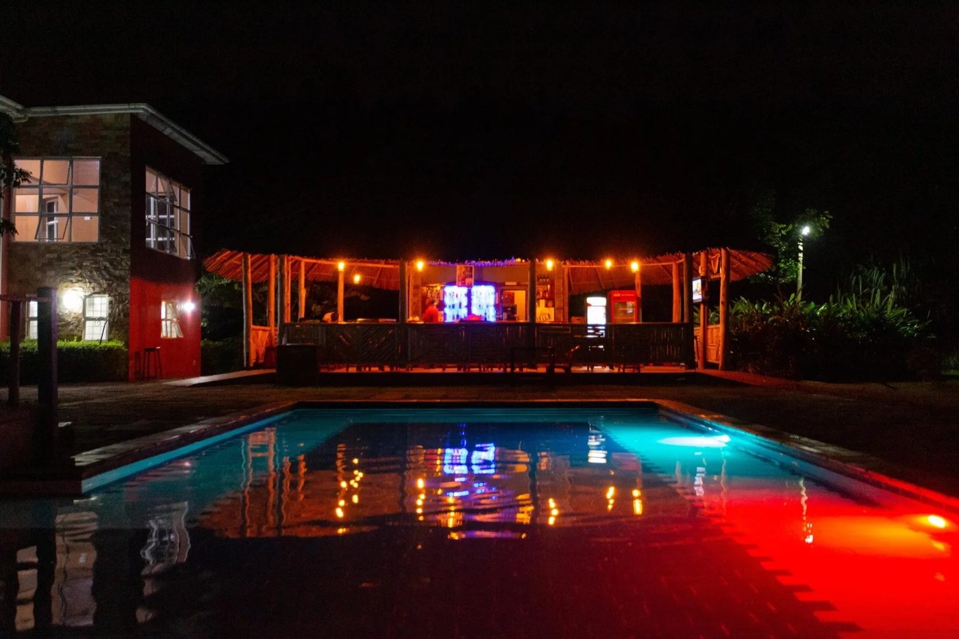Swimmingpool nachts mit farbigem Licht beleuchtet im Kabalega Resort Masindi