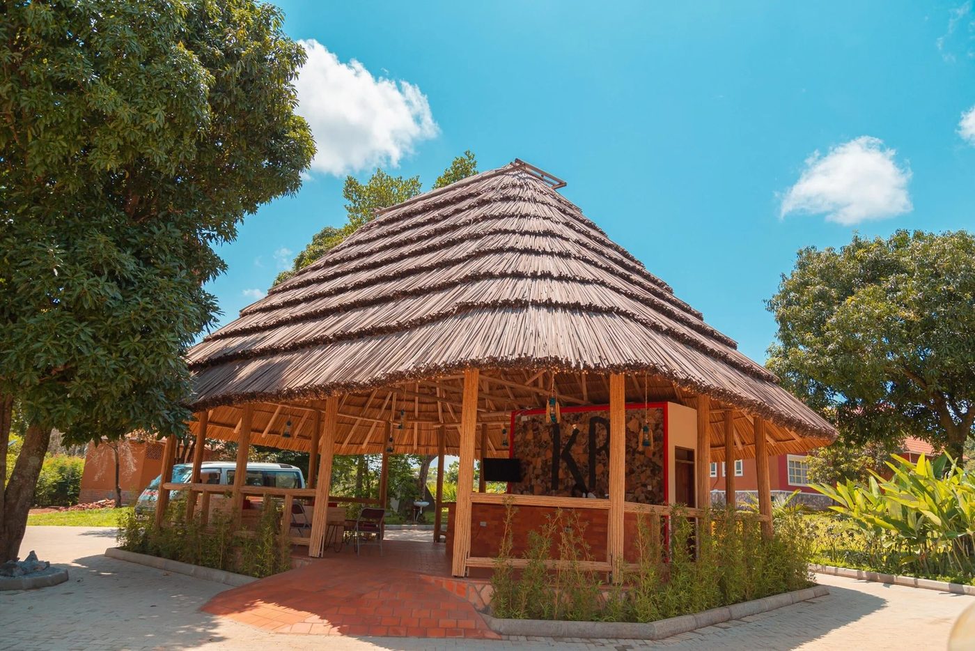 Strohgedeckte Gazebo-Bar auf dem Rasen unter blauem Himmel im Kabalega Resort Masindi