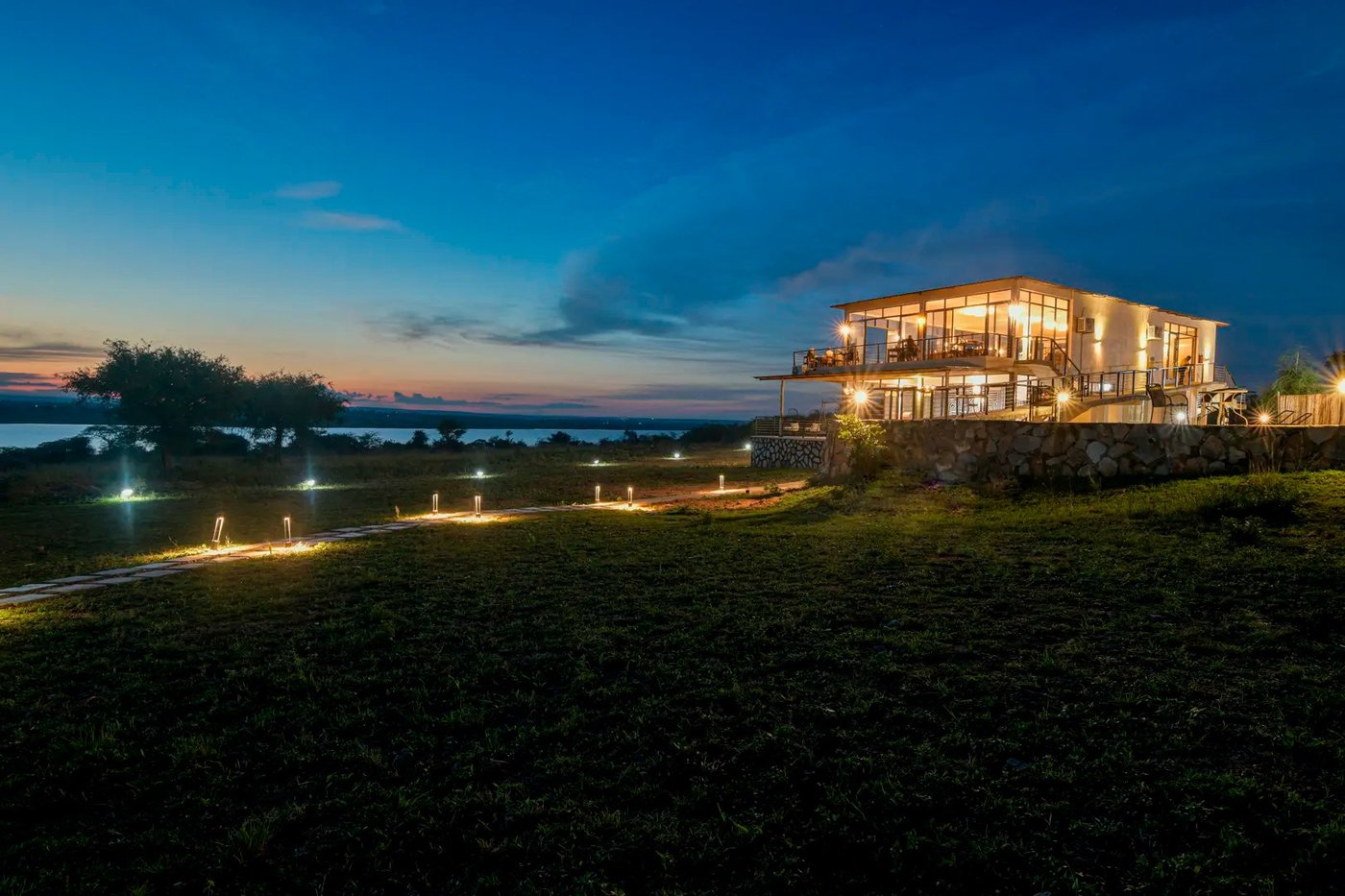 Pakuba Safari Lodge verlicht in de schemering boven de Victoria Nile, Murchison Falls