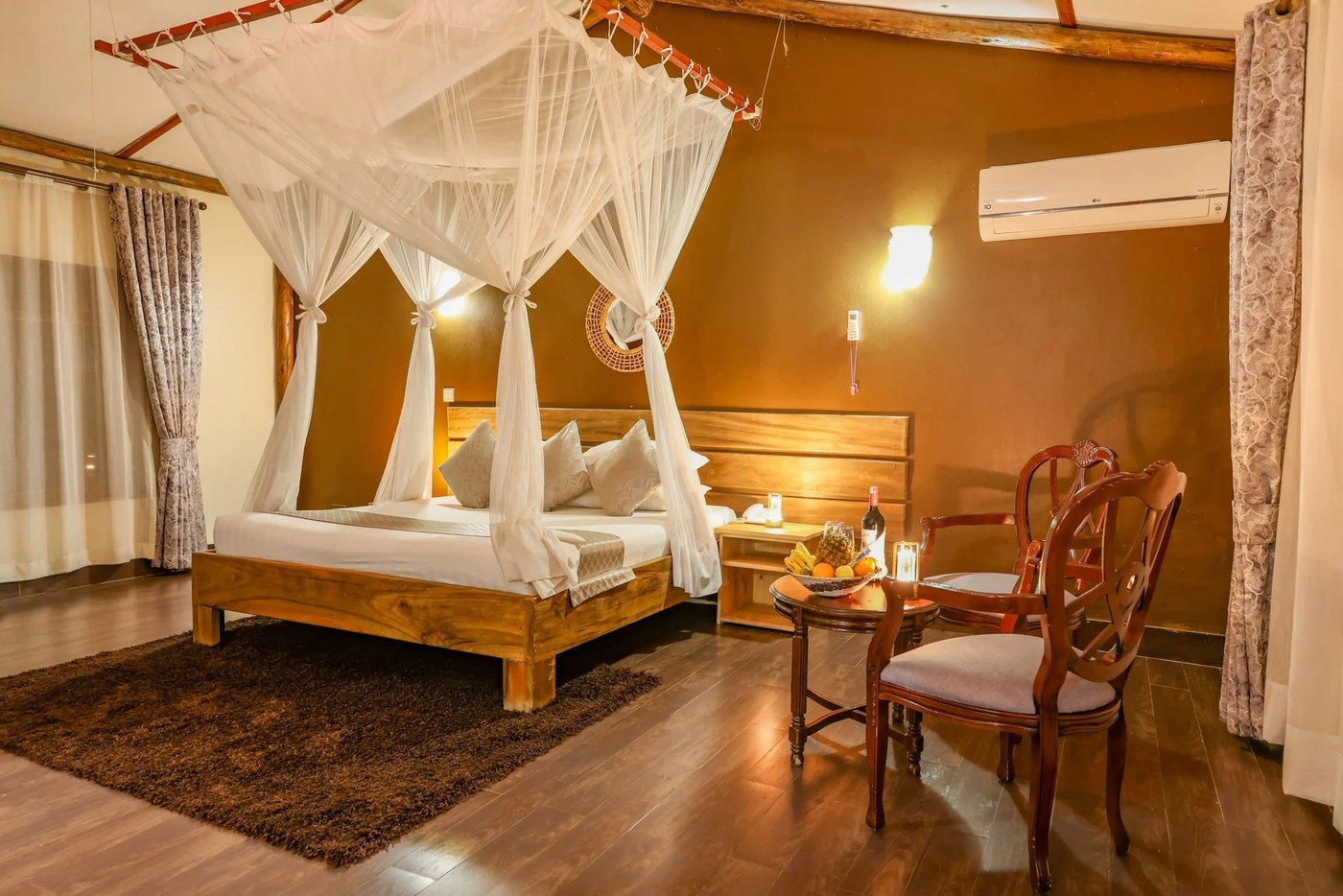 Himmelbett mit Moskitonetz in einem Zimmer in Pakuba Safari Lodge