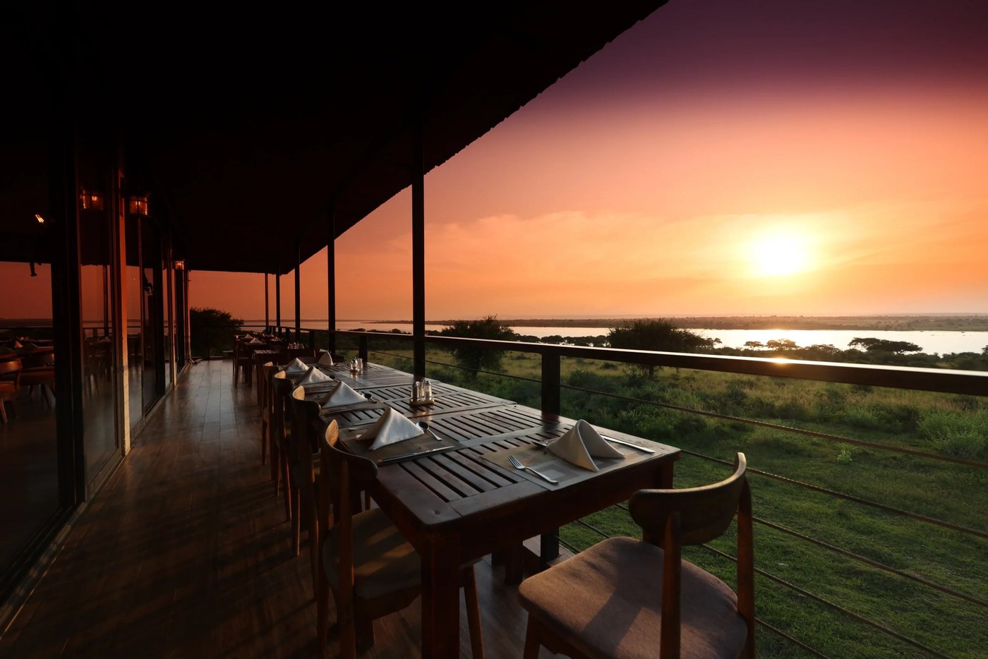Veranda-Esstische mit Blick auf den Fluss bei Sonnenuntergang in Pakuba Safari Lodge