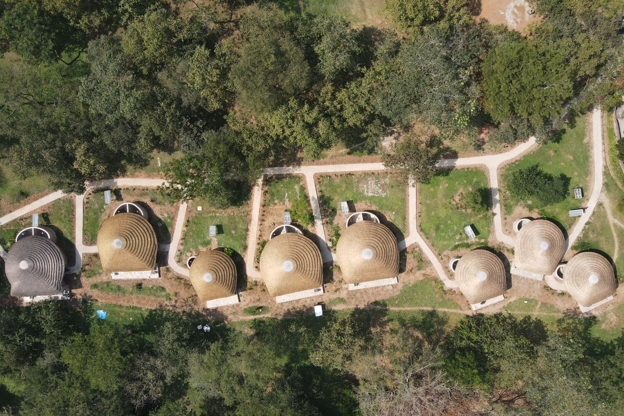 Luchtfoto van de ronde rieten huisjes van Sambiya River Lodge, Murchison Falls