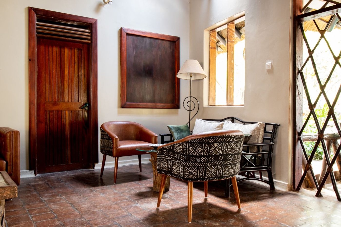 Salon avec fauteuils en cuir contre un mur de brique au Sambiya River Lodge